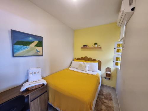 a small bedroom with a yellow bed and a desk at Espaço do acalanto- Quarto em apartamento compartilhado in Natal