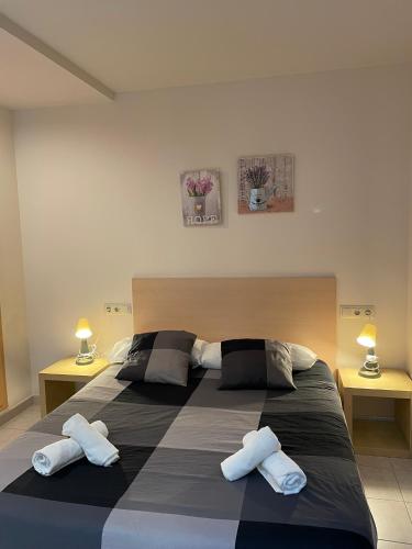 a bedroom with a large bed with two pillows at Apartamentos TDM in Tossa de Mar