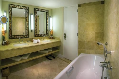 a bathroom with a tub and two sinks and mirrors at Sanctuary Lodge, A Belmond Hotel, Machu Picchu in Machu Picchu