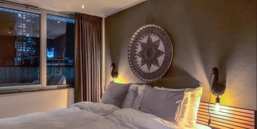 a bedroom with a bed with a clock on the wall at Boutique Hotel Lumiere in Eindhoven