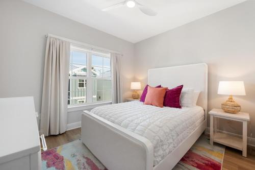 a white bedroom with a white bed and a window at Salty Shells by The Madison Liv Collection in Orange Beach