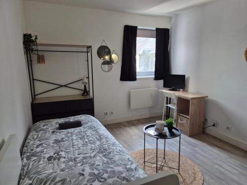a bedroom with a bed and a mirror and a table at Studio - Le Cocon in Saint-Brieuc