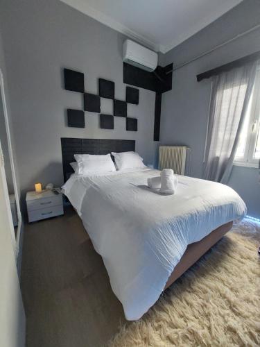 a bedroom with a large bed with white sheets at jim villa family apartment with private yard andravida-kyllini in Andravída