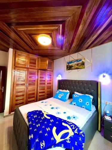 Un dormitorio con una cama grande con almohadas azules. en Golden Apartment, en Douala