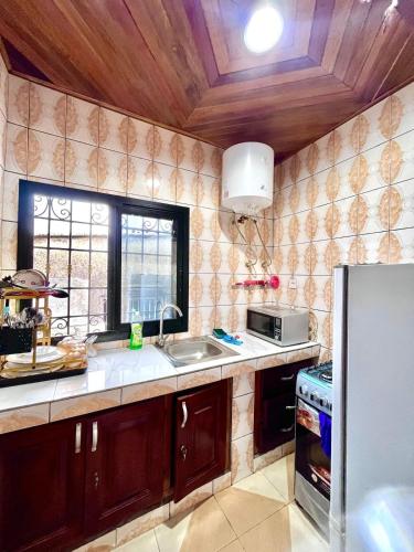 una cocina con fregadero y ventana en Golden Apartment, en Douala
