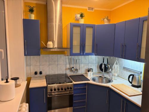 a kitchen with blue cabinets and a sink at Nice apartment close to the beach in Tallinn