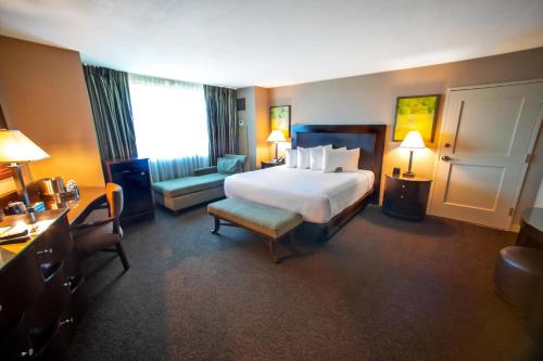 a hotel room with a large bed and a chair at Gold Strike Casino Resort in Tunica Resorts