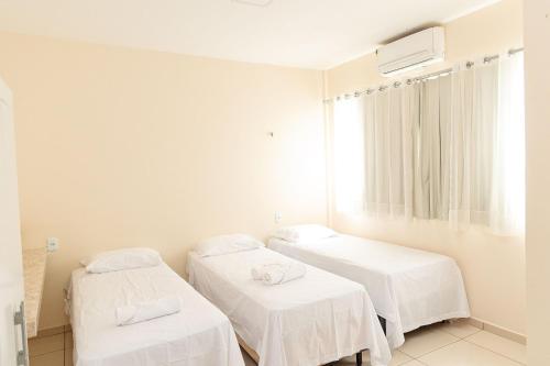 a hospital room with two beds and a window at Pousada Carnaúbas - Sobral in Sobral
