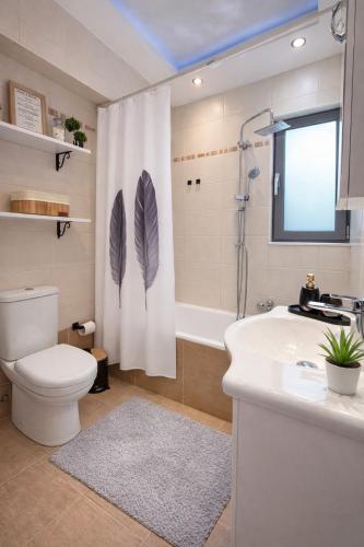a bathroom with a toilet and a sink and a shower at Fos Opus - Seaside Residence Rhodes in Ixia