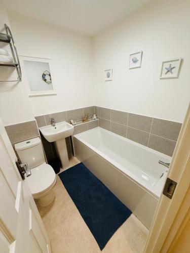 a bathroom with a tub and a toilet and a sink at Gloria's Getaway in Langport