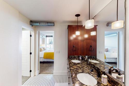 a bathroom with two sinks and a bedroom at 'Downtown Delight' w/ Patio! 1 Mi to Ball State in Muncie