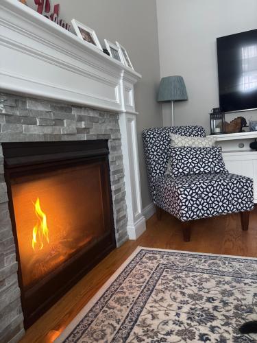 a living room with a fireplace with a fire at 12Birchwood in Holbrook