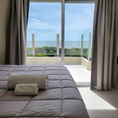 a bed in a room with a large window at Arenas del Este in Costa del Este