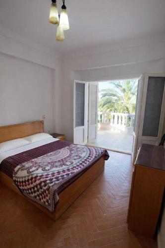 a bedroom with a bed and a sliding glass door at Paradise Villa - King Mariout in King Mariout
