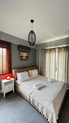 a bedroom with a large bed and a pendant light at Citrus Stone House in Koycegiz