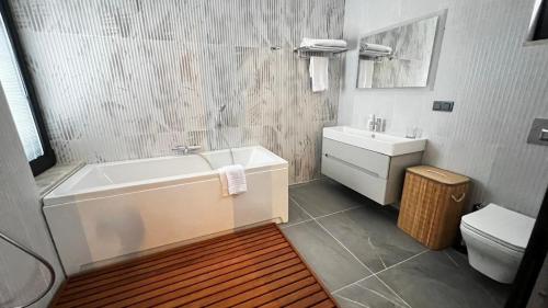 a bathroom with a tub and a sink and a toilet at Citrus Stone House in Koycegiz