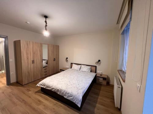 a bedroom with a bed and a wooden floor at Lyra Forest Apartment in Borovets