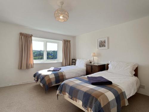a bedroom with two beds and a window at Brightworthy Farm Withypool in Withypool