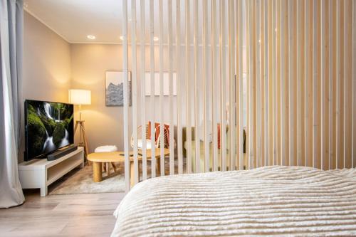 a bedroom with a bed and a table and a television at Coastal Wooden Apartment Rauma in Rauma