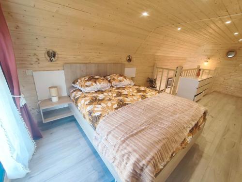 a bedroom with a bed in a wooden room at chalet bohème au calme in Saint-Ambreuil