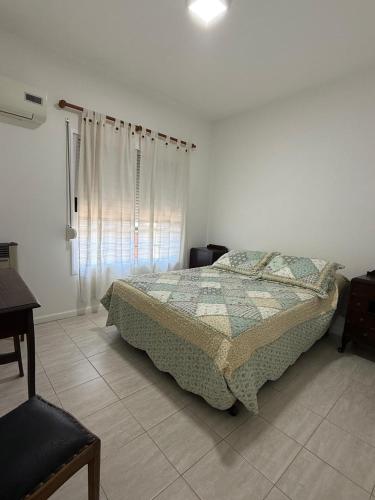 a bedroom with a bed and a table and a window at Departamento Plumerillo in Santa Rosa