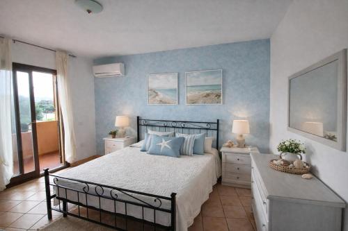 a bedroom with a large bed with blue walls at Il Mirto apartment con piscina in Olbia