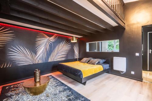 a bedroom with a bed and a wall with a mural at La Cachette - Suite romantique & balnéo privative in Hermeray