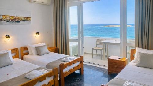 a room with two beds and a view of the ocean at Klinakis Beach Hotel in Chania