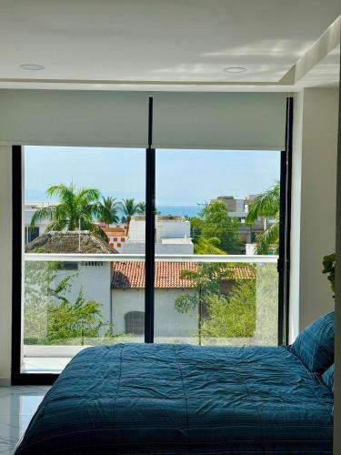 a bedroom with a bed and a large window at 2BR Condo with Ocean View near beach in Bucerías