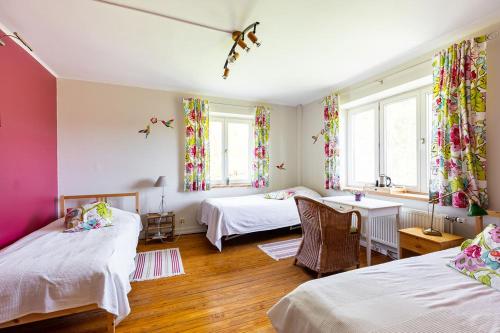 a room with two beds and a table and two windows at Ferme du Banoyard in Theux