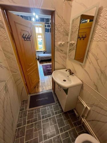 a bathroom with a sink and a toilet and a mirror at Green Vibe Guesthouse in Vanadzor