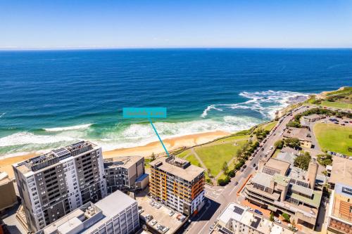 an aerial view of the beach and buildings at Seaside Luxe - L8 - Local Eats, Walks, Swims, CBD in Newcastle