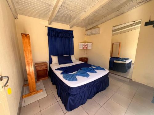 a bedroom with a large bed with blue sheets at Damaris Hostel in Puerto Iguazú