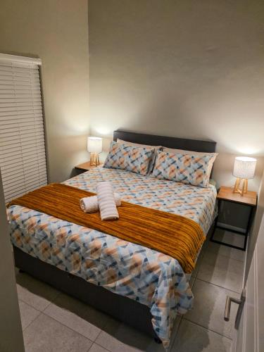 a bedroom with a large bed with two lamps on tables at West Coast Apartment 85 in Langebaan