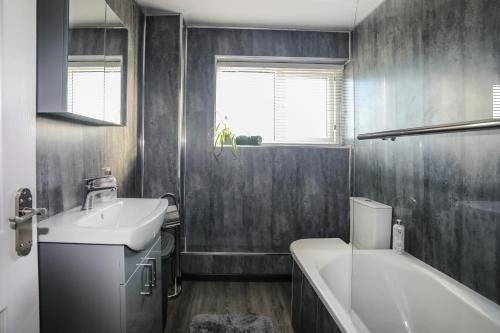a bathroom with a sink and a toilet and a tub at Penrhos Walks in Holyhead
