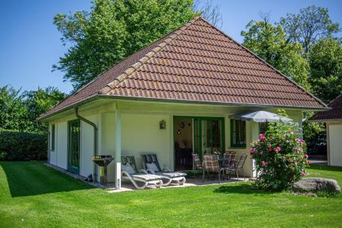 a small house with a table and chairs in a yard at Ferienhaus 2 in Fehmarn