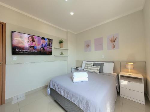 a bedroom with a bed and a flat screen tv at GALILEU - Apartamento próximo à UniCPO, Mondelli, USP, FACOP e FIASP in Bauru