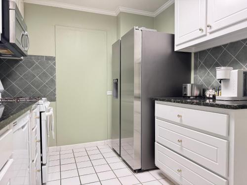 a kitchen with white cabinets and a stainless steel refrigerator at Atlanta Downtown! 3 Unique Apartments Available! Onsite Parking in Atlanta