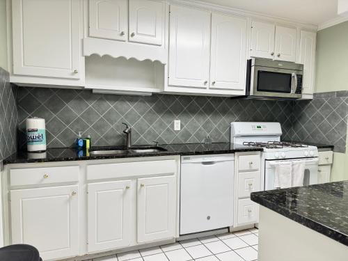 a kitchen with white cabinets and white appliances at Atlanta Downtown! 3 Unique Apartments Available! Onsite Parking in Atlanta