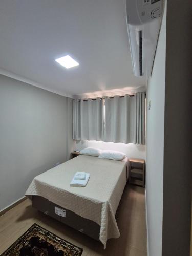 a bedroom with a bed and a window in it at Hotel Canta Galo Tower in Jacarèzinho