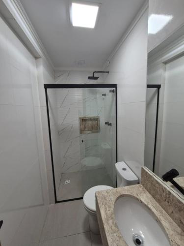 a bathroom with a shower and a toilet and a sink at Hotel Canta Galo Tower in Jacarèzinho