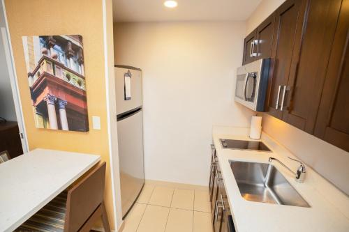 a small kitchen with a sink and a refrigerator at Homewood Suites by Hilton Halifax - Downtown in Halifax