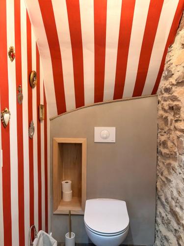 a bathroom with a red and white striped wall at La P'tite Bicoque in Doizieux