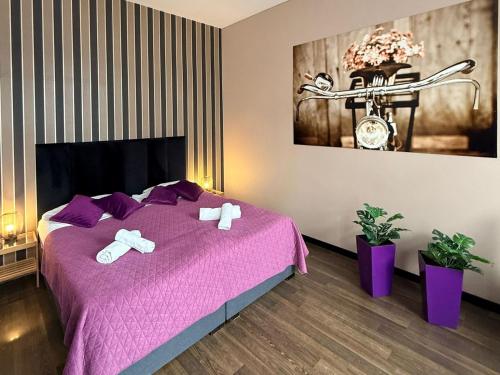 a bedroom with a purple bed with towels on it at Harmonica Studio in Nowy Sącz