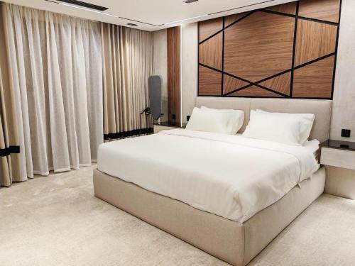 a large white bed in a room with curtains at فلل خاصة في آي بي فاخرة - فندق وأبراج مكة in Mecca