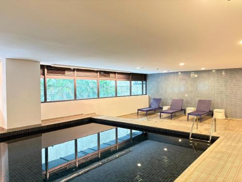 a pool in a house with two chairs and a table at Blue Tree Premium Alphaville in Barueri