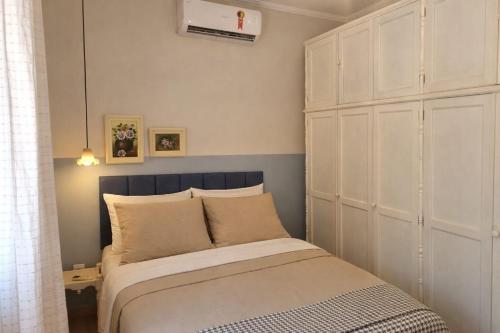 a bedroom with a bed and a large white cabinet at Costa Family-Little house in the center in Santa Rita do Sapucaí