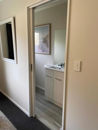 a bathroom with a sink and a mirror at Property close to the beach in Nelson