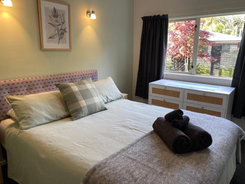 a brown teddy bear sitting on top of a bed at Property close to the beach in Nelson