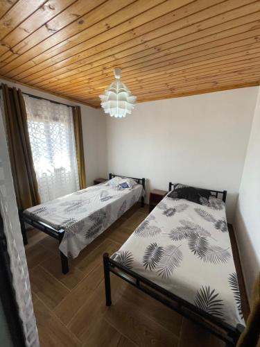 a bedroom with two beds and a chandelier at Akany Sahoby in Antananarivo